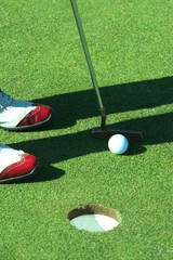 Golf putting and red shoes