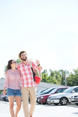 Obraz premium Happy couple walking on city street against clear sky