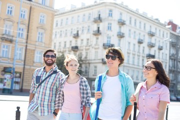 Happy male and female friends walking on city street
