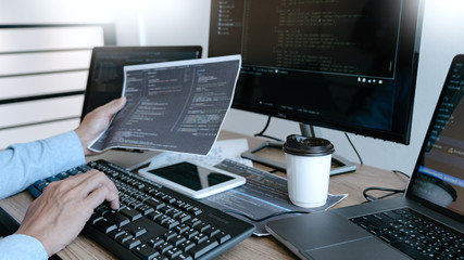 Programmer working On Computer In IT Office Typing Data Coding in software and checking code on computer screen.