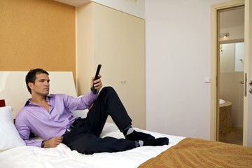 Man on bed with remote control