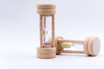 Two hourglass put on wihte blackground,sand in side,one si purple,one is yellow.