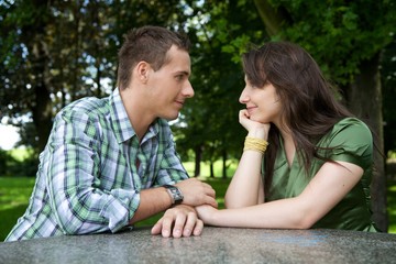 Fototapeta premium Young couple holding hands and looking at each other