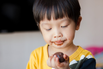 Young asian boy with face covered in chocolate