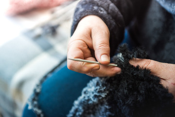 Close up photography of a knitting needle. Woman hands knitting a scarf.