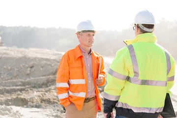 Supervisors discussing at construction site on sunny day