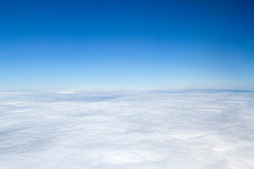 Aerial view above the clouds with blue sky