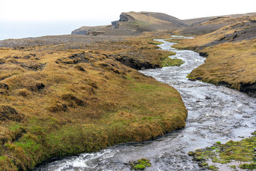 Ketubjorg bird cliffs in the Skagi peninsula. Creek used as leading lines. Shapes, texture and pattern in the Icelandic nature concept.
