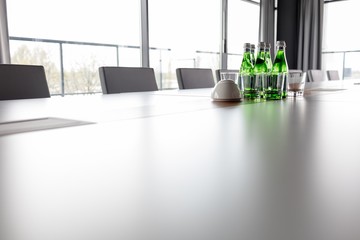Water bottles and drinking glasses on conference table in office