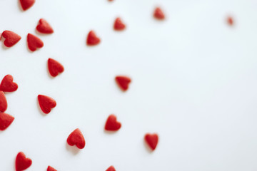 red confetti in the shape of hearts on a white background copy space.	