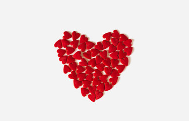 Obraz na płótnie Canvas heart of red confetti confectionery on a white background. valentines baking decor. 