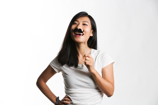 Young attractive woman holding mustache photo booth props 