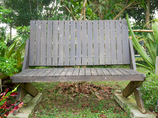 Counter the old brown wood in a garden with green trees.