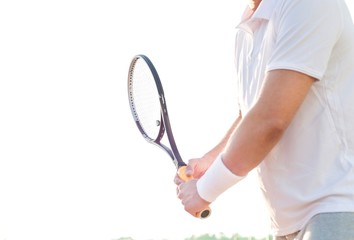 Tennis player holding racket and ball