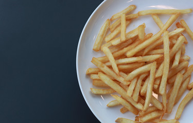Heap of French fries on a white plate