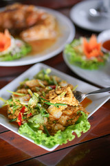 Fried crab with curry powder. Thai cuisine seafood menu of crab curry stir fried. Soft focus on the portion of curry and crab meat on the spoon.