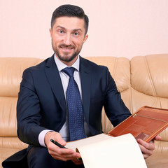 successful business man engaged in business documents sitting on a leather sofa