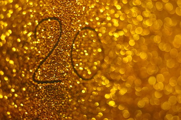 Golden wall with the inscription 2020 and disappearing numbers after 20 on a shiny background.