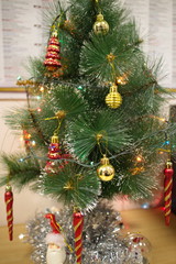 Artificial green Christmas tree with red toys