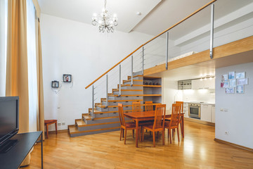 Interior in warm tones. Private house. Staircase to the second floor. Kitchen set.