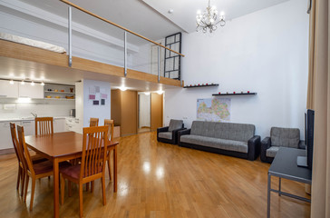 Modern interior of studio apartment. Kitchen set. Wooden table. Cozy couch.
