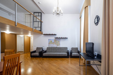 Modern interior of studio apartment. Wooden table. Cozy couch.