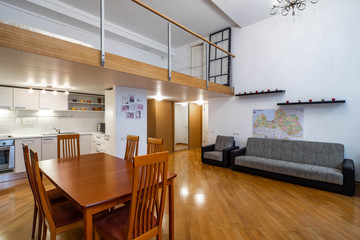 Modern interior of studio apartment. Kitchen set. Wooden table. Cozy couch.