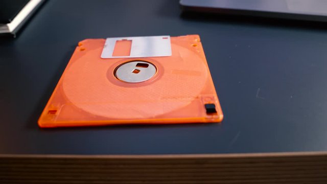 orange Floppy disk on the table , old type of data storage , Retro floppy disk sitting on the desktop , 