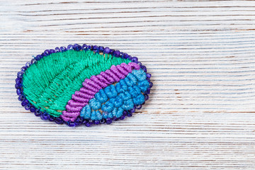 oval brooch embroidered by silk threads on gray