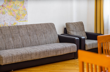 Furniture in private house. Sofa and chair. Close-up. White wall.