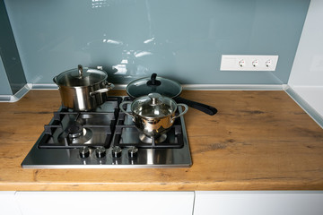 Modern stainless steel gas stove oven in a home with various cookware