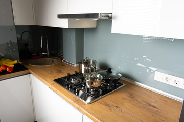 Modern stainless steel gas stove oven in a home with various cookware