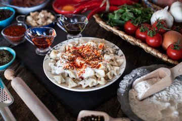 Turkish ravioli manti preparation with meat, yoghurt, butter and red pepper. Mantı concept stock photo. 