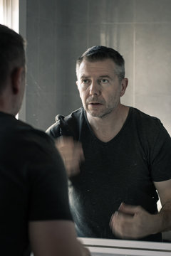 Man In Grey V-neck Tshirt Staring At Himself In Bathroom Mirror