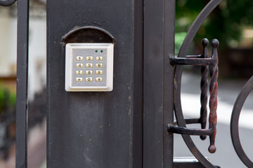 electronic security lock for access with buttons for entering the installed password on the iron forged gate, fronte view close up safety device.
