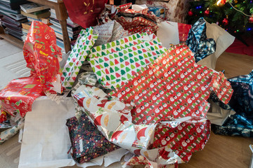 Piles of discarded Christmas wrapping paper left on the floor after presents have been opened.