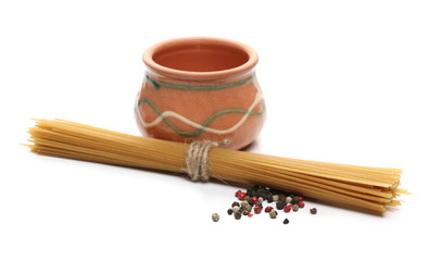 Raw spaghetti bundle with mixed, colorful peppercorns and clay bowl, isolated on white background 