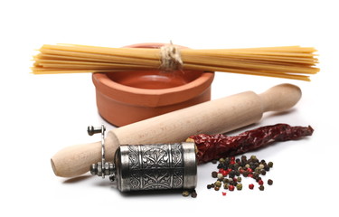 Raw spaghetti bundle with mixed, colorful peppercorns, peppercorn mill, wooden roller and clay bowl, isolated on white background 