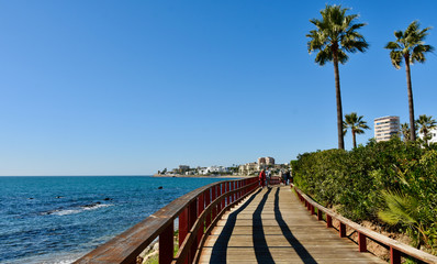 Boardwalk along the Spanish Costa del Sol  on a cloudless day - obrazy, fototapety, plakaty