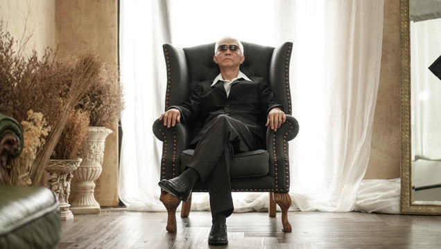 Senior Asian man handsome and suit sitting in rich expensive house