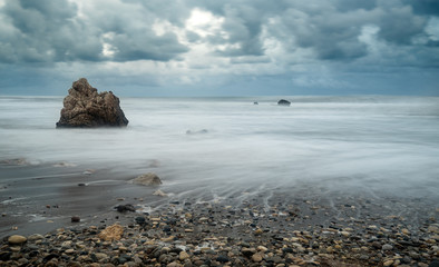 Seascape with windy waves during storm weather a  rocky coastline