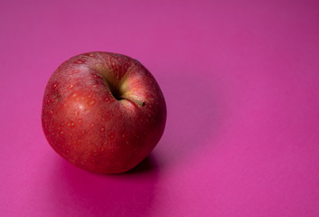 Fresh apple fruit isolated on a magenta background