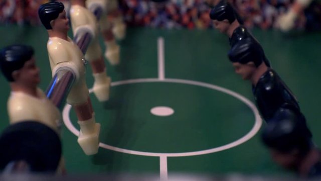 foosball.small plastic players in the table soccer.game kicker close up.Shallow depth of field.