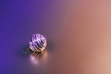 A shiny Christmas decorative ball on two colored background. Place for text.
