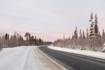 Fototapeta premium Winter road in the middle of snowy forest