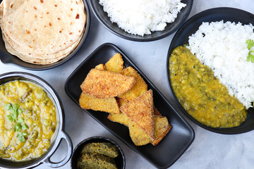 Assorted Indian food for lunch or dinner, rice, spinach lentils/Palak dal, Roti or naan, Alu Vadi and surnache kap / Yam fry. selective focus with Copy space