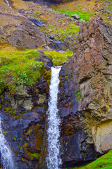 Breathtaking waterfall cascade with mountains in amazing nature scenery and landscape near...