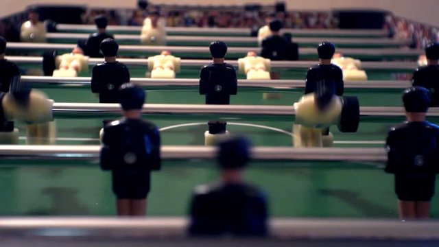Games, entertainment, hobbies and leisure.foosball.plastic players in the table soccer.game kicker close up.Shallow depth of field