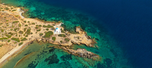 Aerial drone ultra wide photo of iconic small chapel of Agios Panteleimon next to emerald beach of...