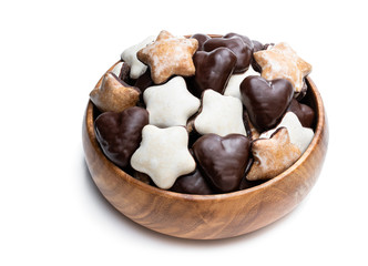 Sugar and chocolate glazed seasonal spiced cookies in wooden bowl isolated on white